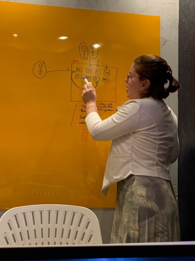 Adair Christina escrevendo no quadro durante uma formação presencial